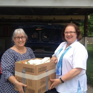 Two female parishioners dropping off a donation.
