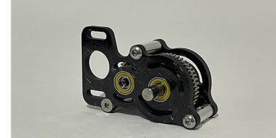 Close-up of a small mechanical gear assembly with bearings and screws.
