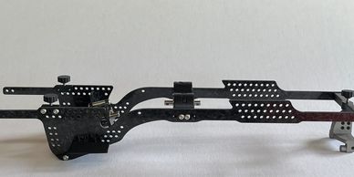 Black metal chassis frame with perforations and adjustable components.