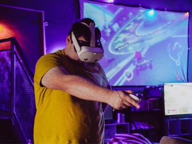 Person playing VR game with headset and controller.