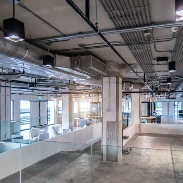 Spacious industrial-style office interior with exposed ceilings.