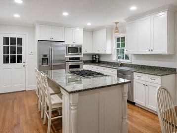 Bright modern kitchen with island and granite countertops.