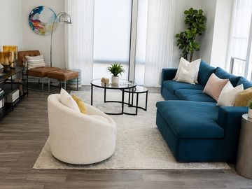 Modern living room with a blue sofa and a white round chair.