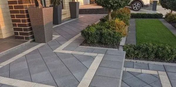 Modern garden path with geometric tiles and greenery.
