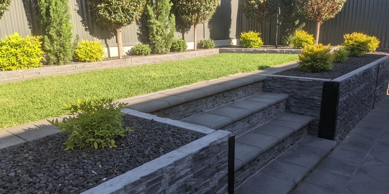Modern garden with trimmed bushes and stone steps.