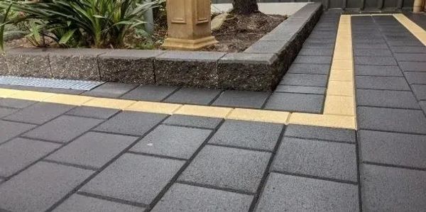 Outdoor garden with gray and yellow paving stones.