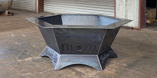 Metal hexagonal fire pit on concrete floor.