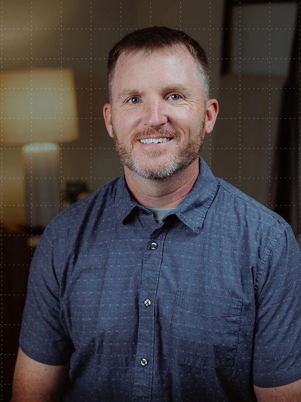 Smiling man in casual blue shirt.