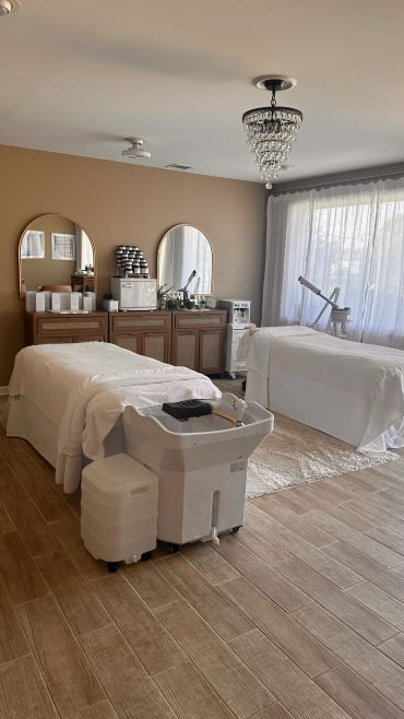 Elegant spa room with two massage tables and soft natural light.