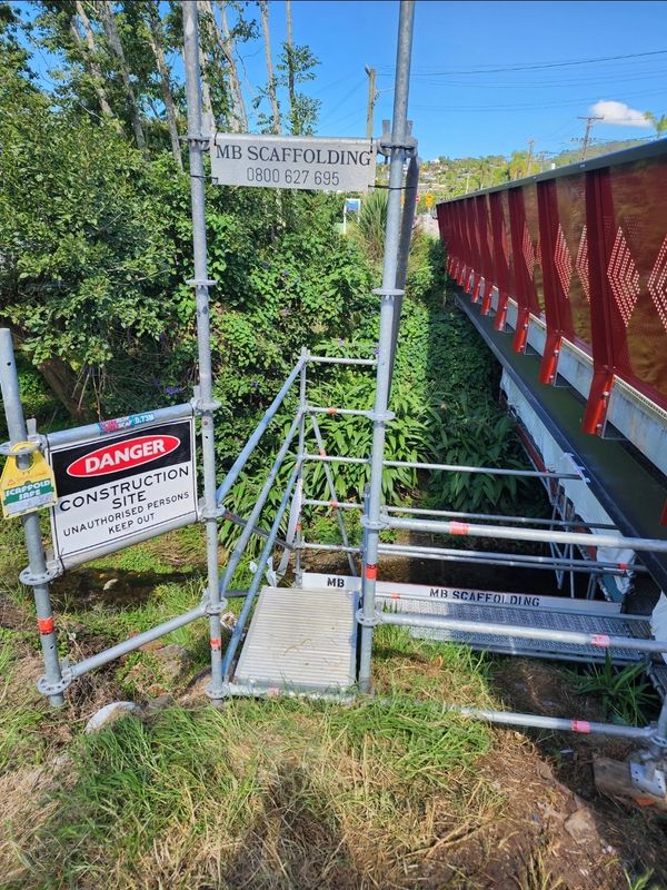 Stairway access leading to a scaffolded and shrinkwrapped bridge completed in Whangarei Central 