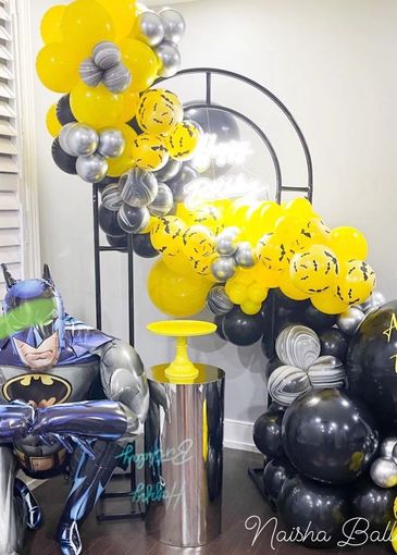 Batman-themed birthday party setup with yellow, black, and silver balloons.
