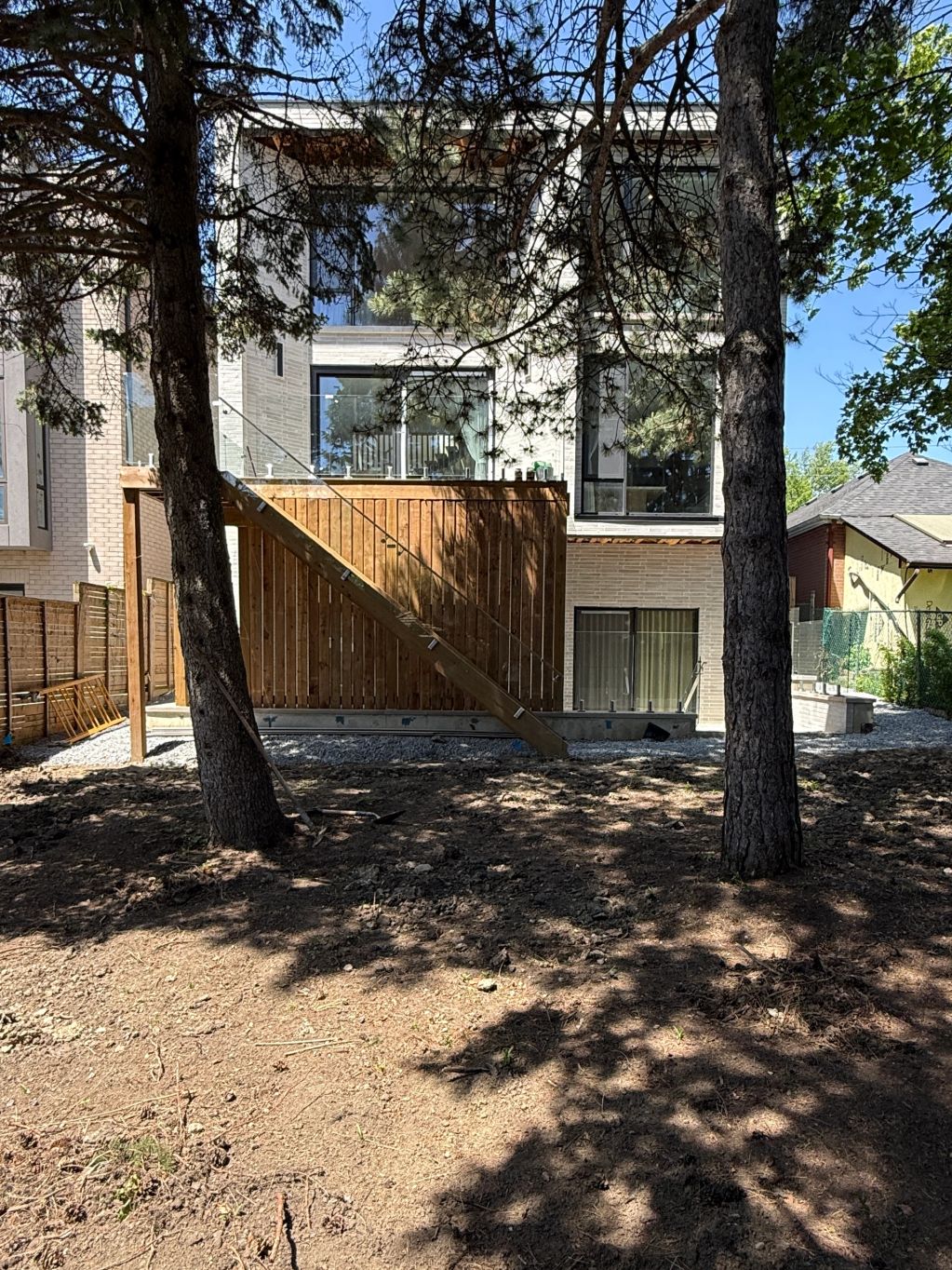 Modern house with wooden stairs and trees.