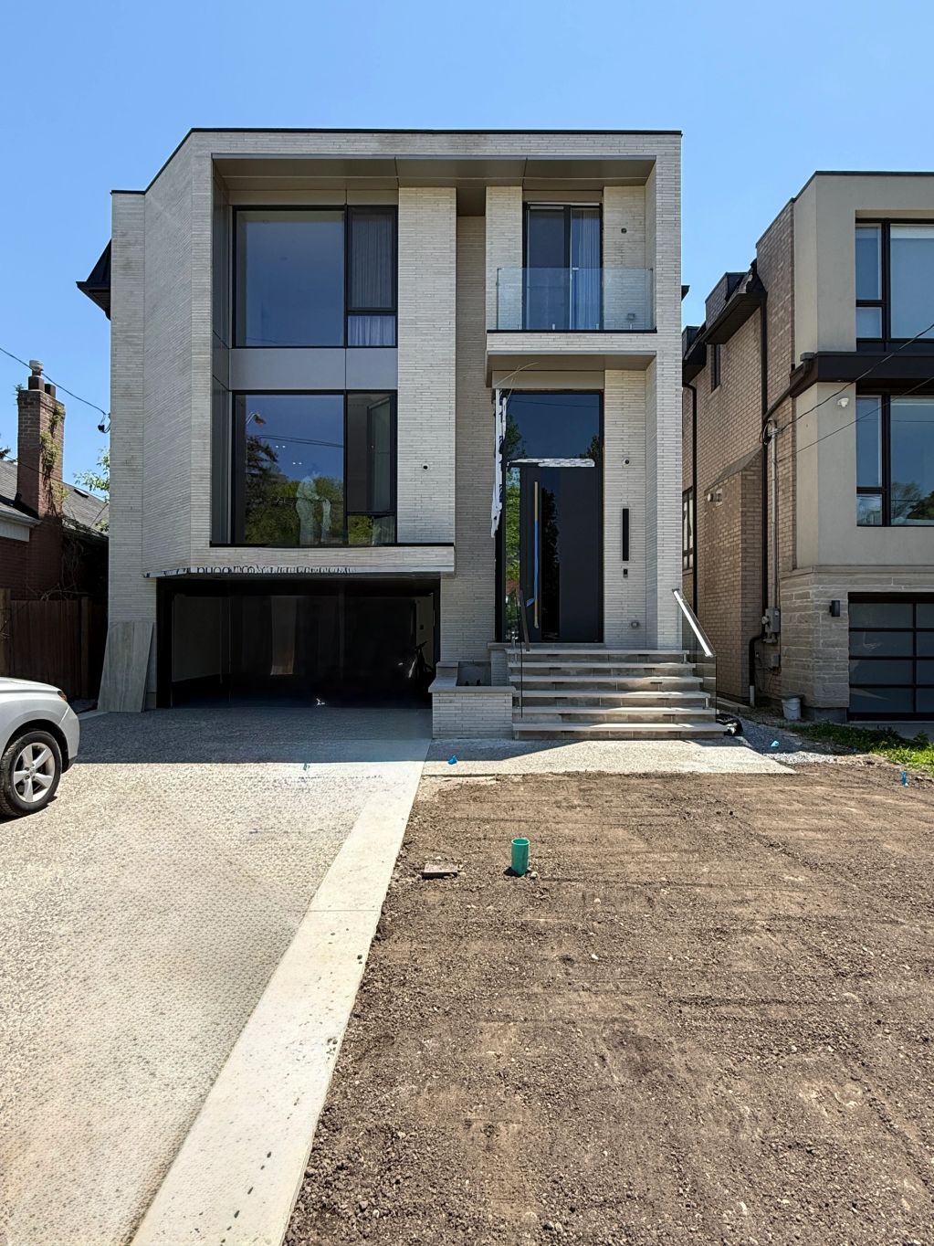 Modern two-story house with large windows and clean design.