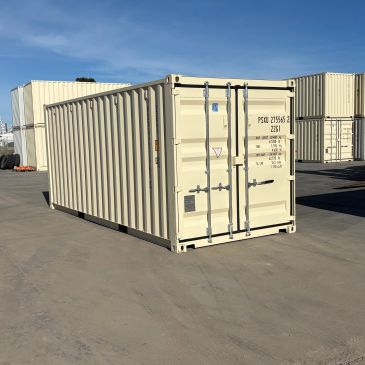 Beige shipping container on a concrete surface under clear sky.