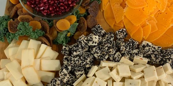 Cheese and dried fruit platter with pomegranate seeds.