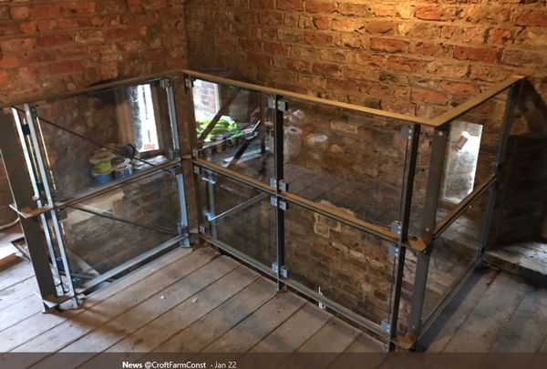 A photograph of a glass balustrade inside the red tower, york. metal frame work.