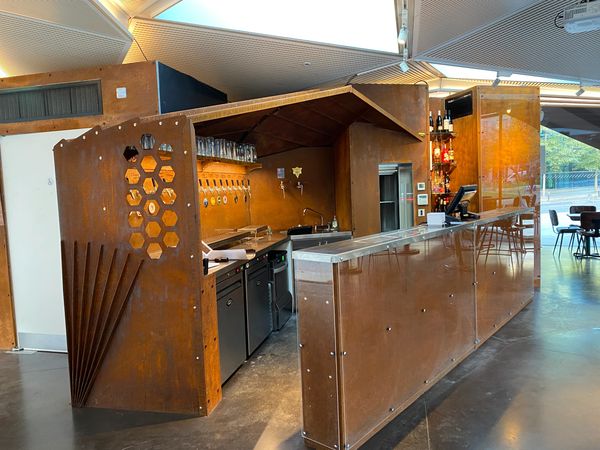 Photograph of a corten metal plasma cut bar. shape to match Aldgate roof.