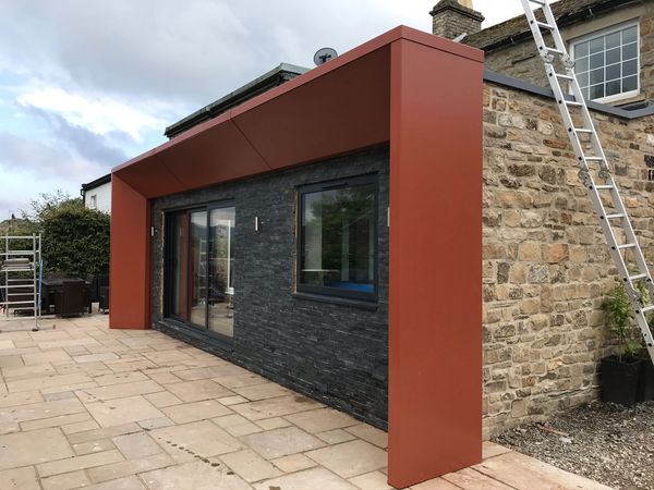 Photograph of a metal frame decoratively surrounding a back of house wall. 