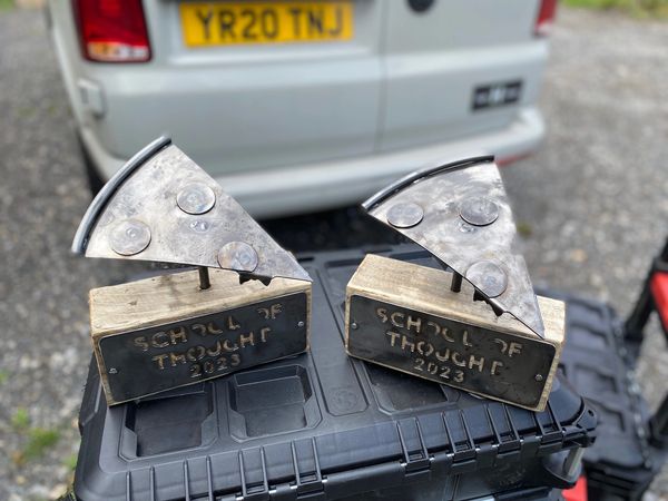 Photo of a trophy, metal pizza slice mounted on wooden block, school of thought plasma cut on the si