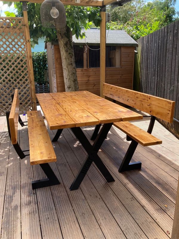 Photo of a garden dining table with two benches, metal box frame legs wooden boards table top and se