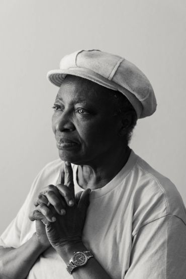 Thoughtful elderly person wearing a cap.