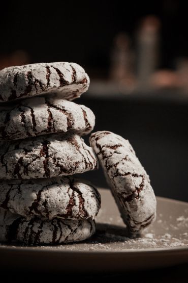 Stack of powdered chocolate crinkle cookies.