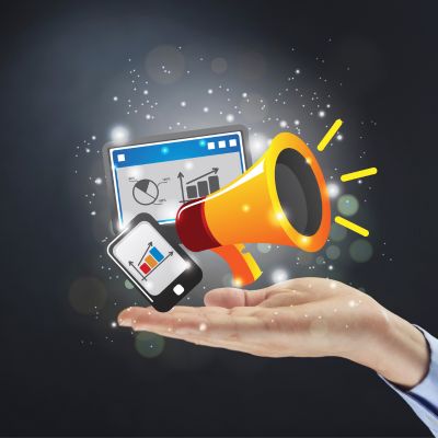 Image of a hand holding a mobile phone, computer screen and megaphone indicating communication of da…