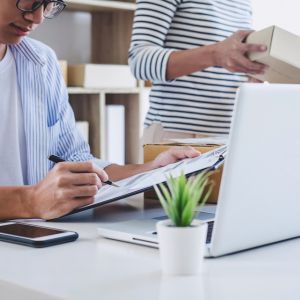 Picture of 2 people working at a small business, looking at a computer