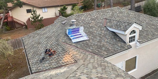 Rooftop with roofers working and roofing materials.