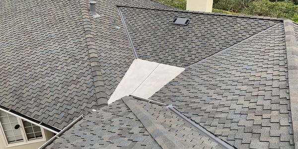 Close-up of a shingled roof with metal flashing.