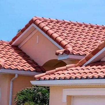 House with terracotta roof tiles under a clear blue sky.