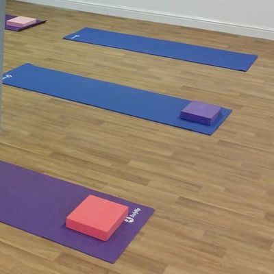Yoga mats with blocks on a wooden floor.