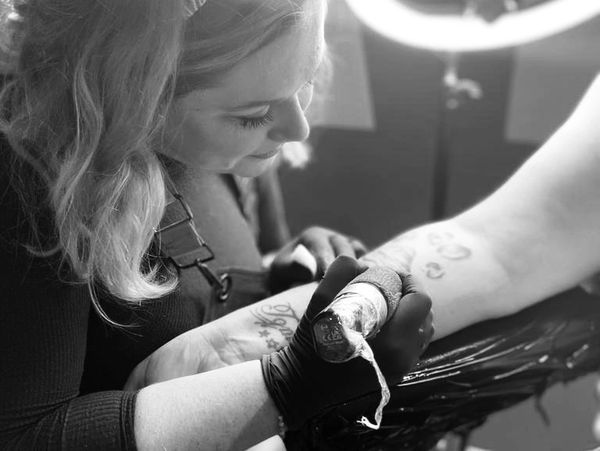 Tattoo artist Cat Beazeley tattooing an arm