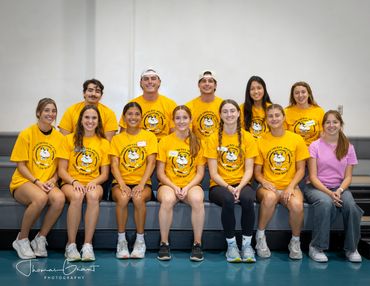 Group photo of young people wearing yellow shirts with a mascot logo.
