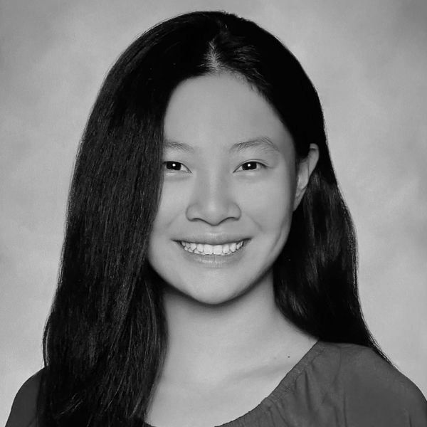 Black and white portrait of a smiling woman with long hair.