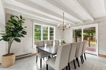 Bright dining room with eight chairs and a chandelier.