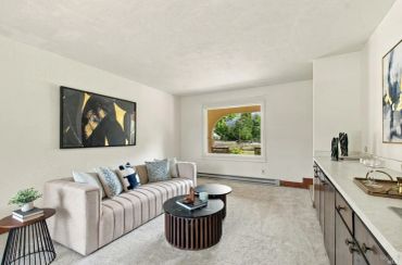 Cozy living room with beige sofa and large window.