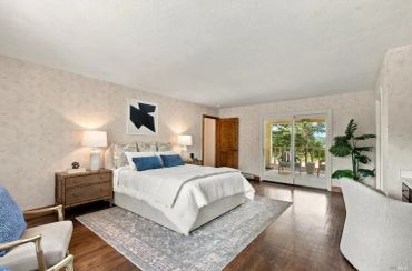 Cozy bedroom with a large bed and sliding glass doors.