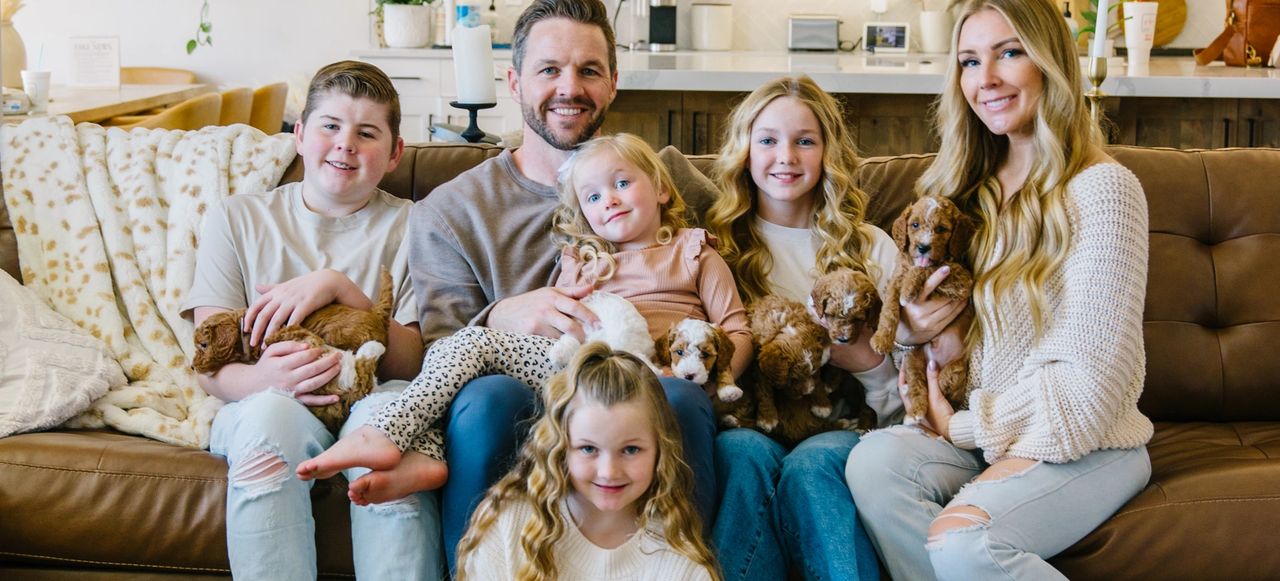 The Leany family with their Goldendoodle puppies