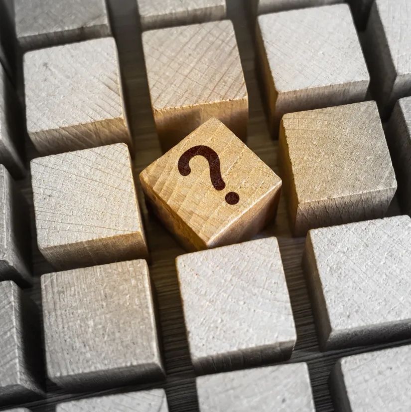 Wooden blocks with one block featuring a question mark.