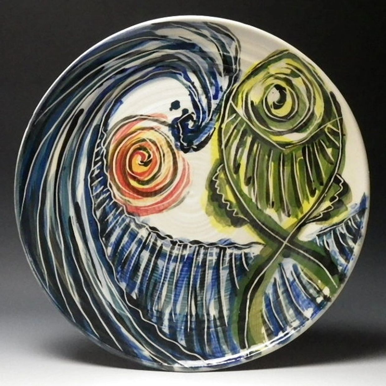 Handmade porcelain dinner plate with a huge blue wave, orange sun, and green fish painted on it