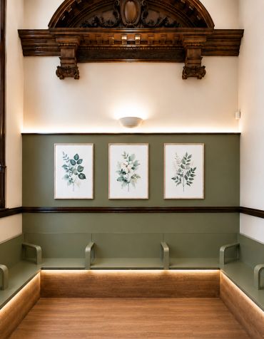 Elegant waiting area with green seating and botanical artwork.
