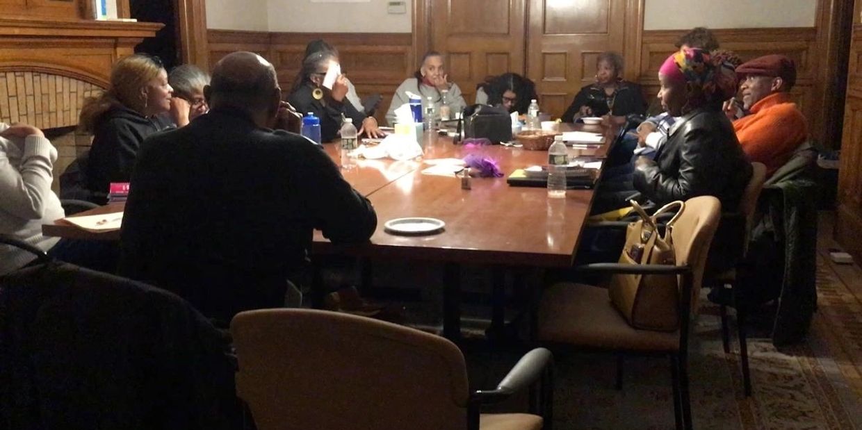 Journey Writers members seated around a large wooden table.