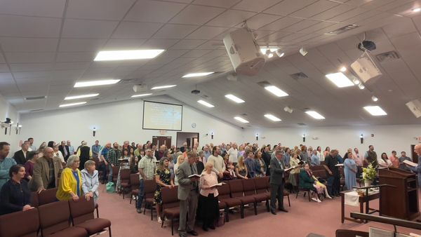 A congregation standing inside a church during service.