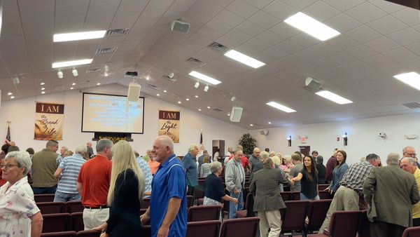 Congregation members mingling inside a church after service.