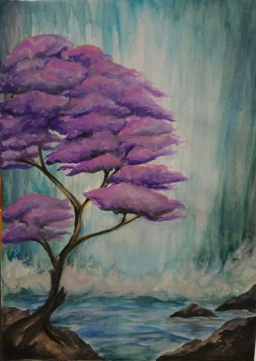 A tree with purple leaves by a water body and rocks.