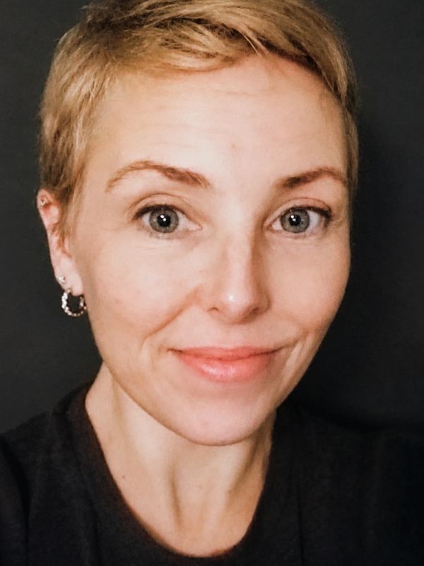 Close-up portrait of a woman with short blonde hair and a gentle smile.