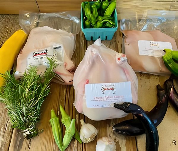 Packaged poultry with fresh herbs and veggies.