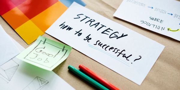 Notes on strategy and success with pens and sticky notes on a desk.