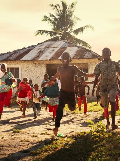 Group of African Little Children Running Towards the Camera and Laughing in Rural Village